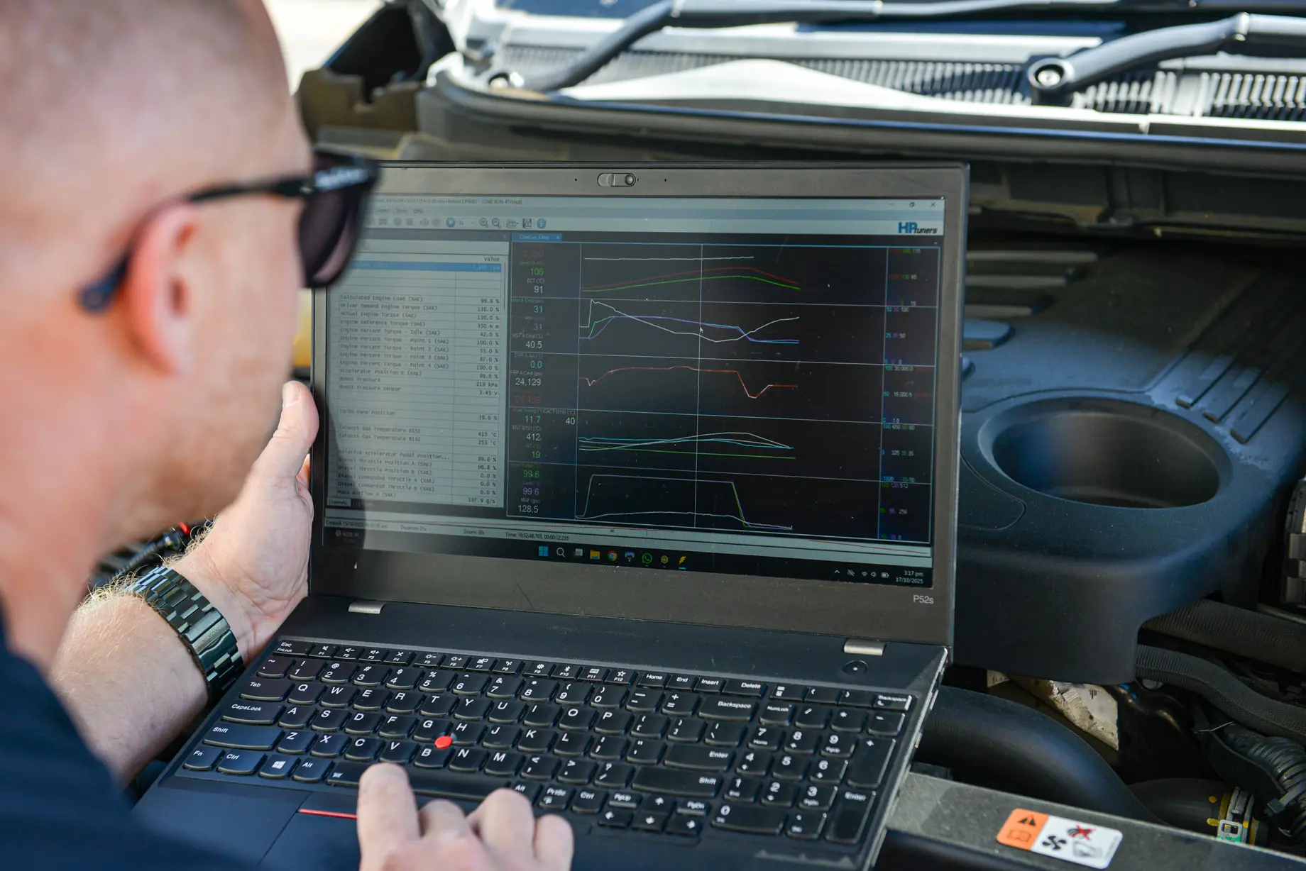 Dave working from a laptop on the guard of a diesel ute at the customer's place
