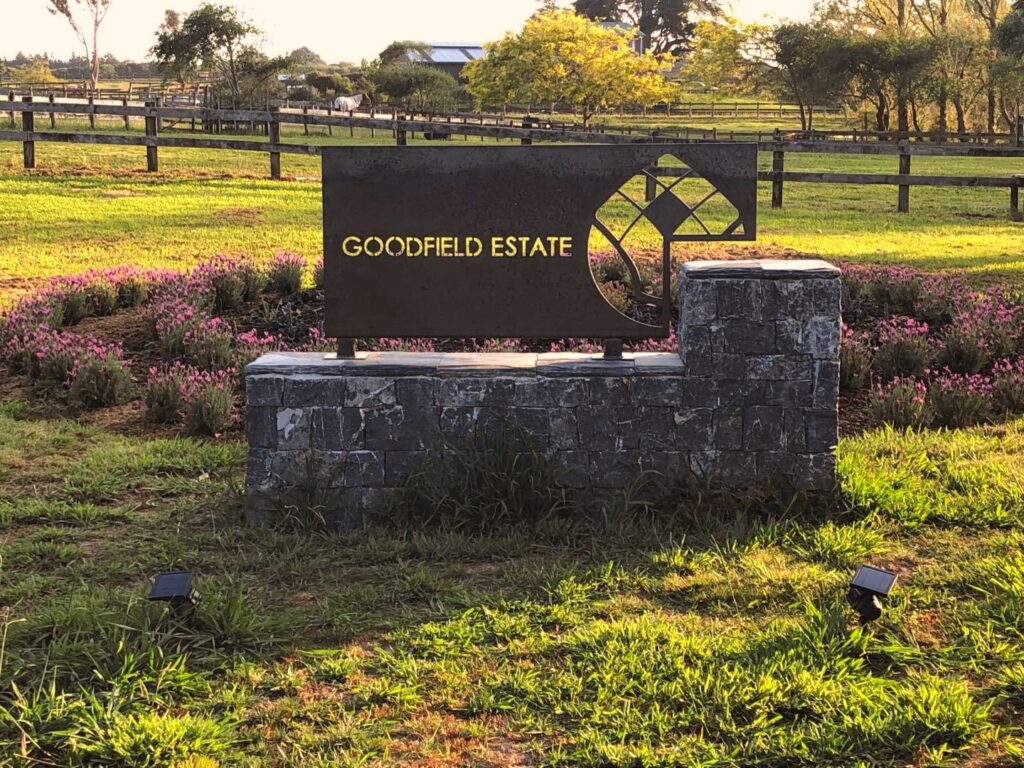 Stone and metal entrance sign at a rural estate
