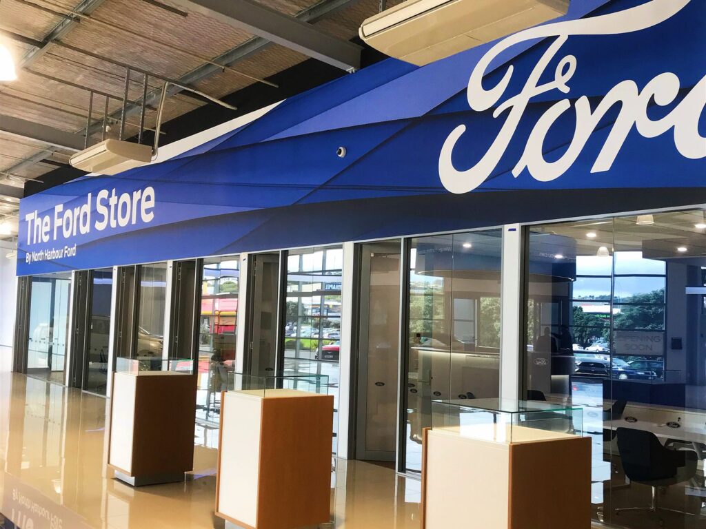 Car showroom interior with a branded fascia and display plinths
