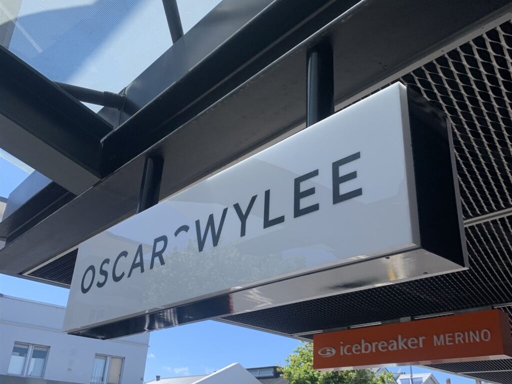 Lightbox sign hanging under a shop veranda